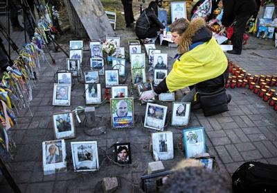 乌克兰总统独立广场跪地悼念骚乱遇难者(图)
