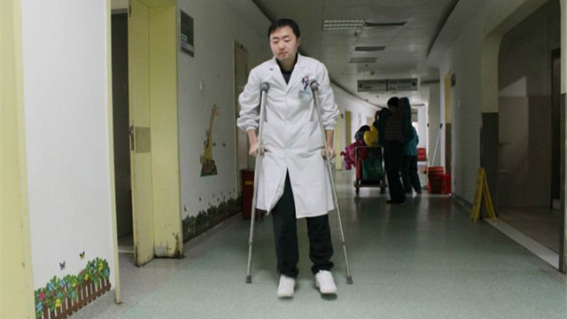 武汉一儿科医生拄拐杖给孩子看病