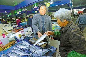 图为市民正在菜市场选购马鲛鱼。(徐能摄)