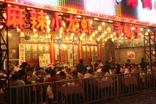 资料图：食客在北京东直门簋街一家餐馆品尝美味。位于北京东直门的簋街是一条著名的特色餐饮街。
