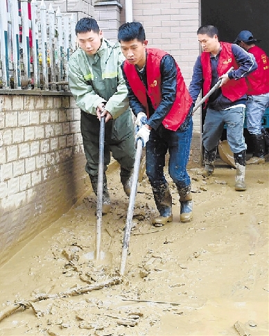 5月8日，临安清凉峰镇村干部、党员群众、好家风志愿队积极投入抗灾抢险工作，农户也开展生产自救。图1为好家风志愿队在清理淤泥。金凯华 摄