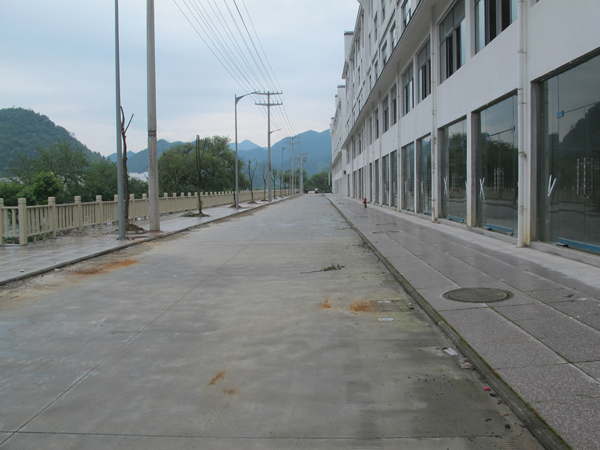 桂建杰停车的路段是一条背街小路，商铺建成并未装修营业。 澎湃新闻记者 周琦 图