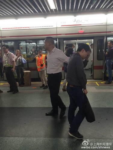 上海地铁站内一男子偷拍女乘客裙底 被男乘客抓现行 