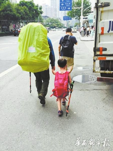 6月14日，来自江西上饶的“中国最小背包客”雯雯随父亲来到成都。图为父女俩行走在蓉城街头。
