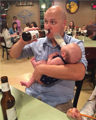 父亲一手抱着吃奶的宝宝,一手拿起一瓶啤酒尽情饮用;女儿在爸爸玩