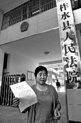 昨日上午11时许，柯长桂拿着判决书站在柞水县人民法院门外