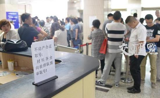 图为南京广州路房产交易登记中心内，满是排队人。