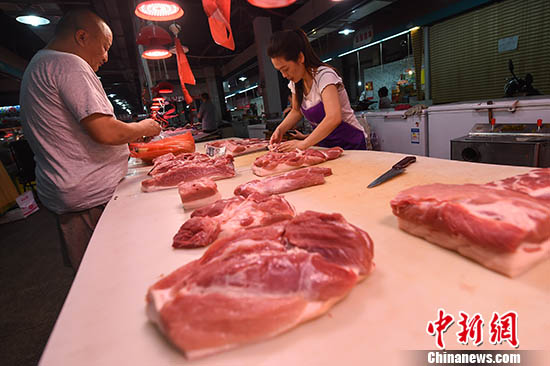 资料图：山西太原，民众在菜市场选购猪肉。中新社记者 武俊杰 摄
