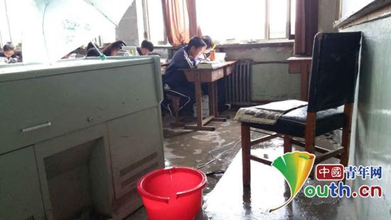 教室内地上放着桶，接屋顶漏水。