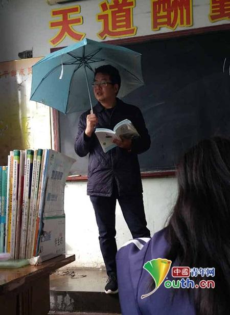老师打伞上课。