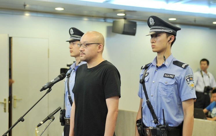 9:09 身着黑色t恤的李代沫被法警带入法庭