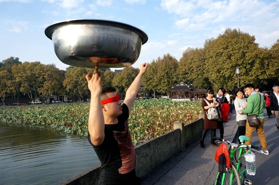 西湖断桥"脸盆哥"逗乐游人(1/6)