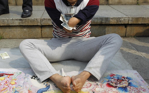 无手小伙用脚绣十字绣 想攒钱给妈妈买洗衣机