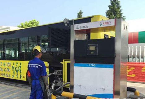 中石化工作人员在华丰公交车站给lng液化天然气客车加气