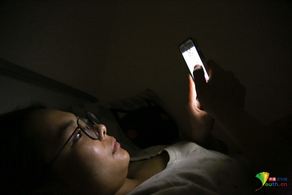 宿舍晚上十二点断电关灯,一位同学继续用手机网购.