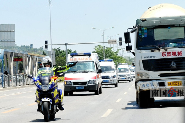 图为交警铁骑正在用手势指引社会车辆为救护车队让行.