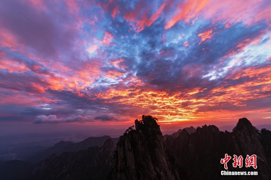 一輪紅日從東方的天與雲之間騰空升起,隨之旖旎朝霞開始延展,染紅了