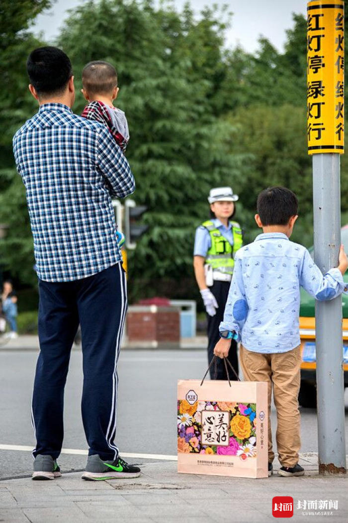 中秋节父子提月饼街头守望交警妈妈 换岗间隙一家团聚