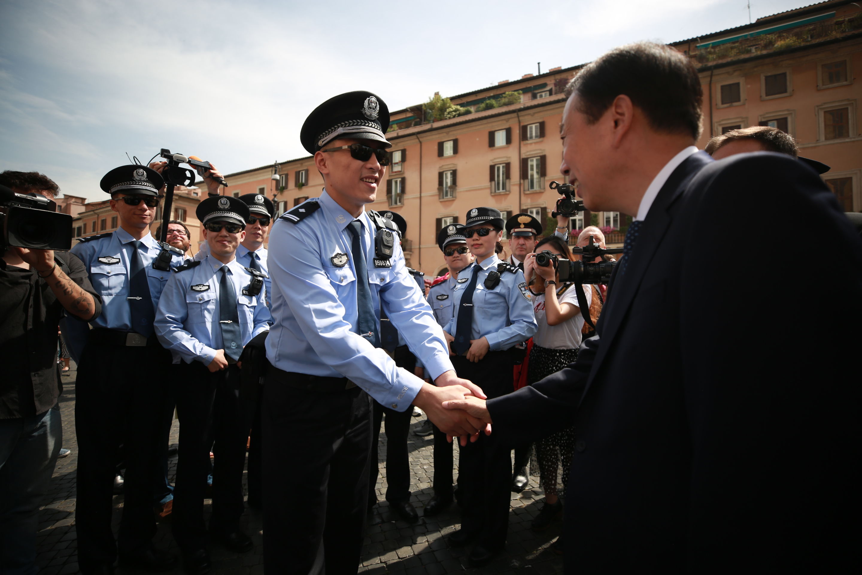 中国驻意大利大使李瑞宇与中国警员代表握手