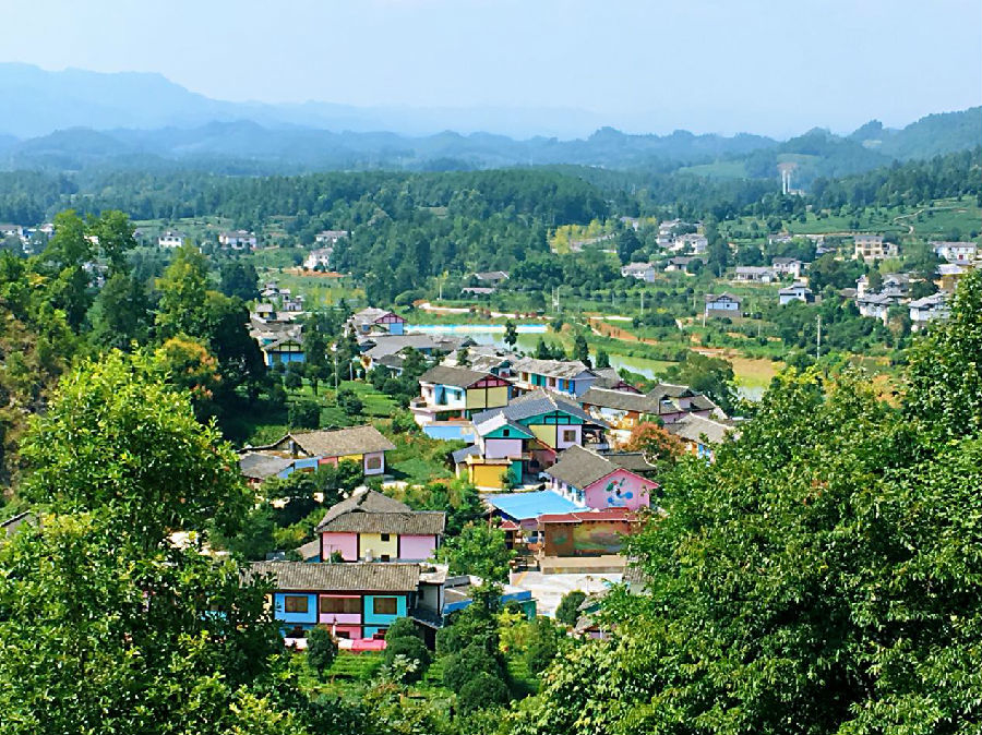 空旷的坝子上一幢幢五颜六色的房子坐落在一起,乍眼一看以为走进了