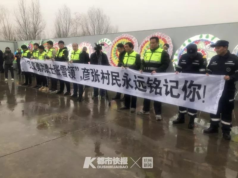 追悼会现场两侧,有人拉起"沉痛悼念英雄,英雄一路走好"的横幅,许多人