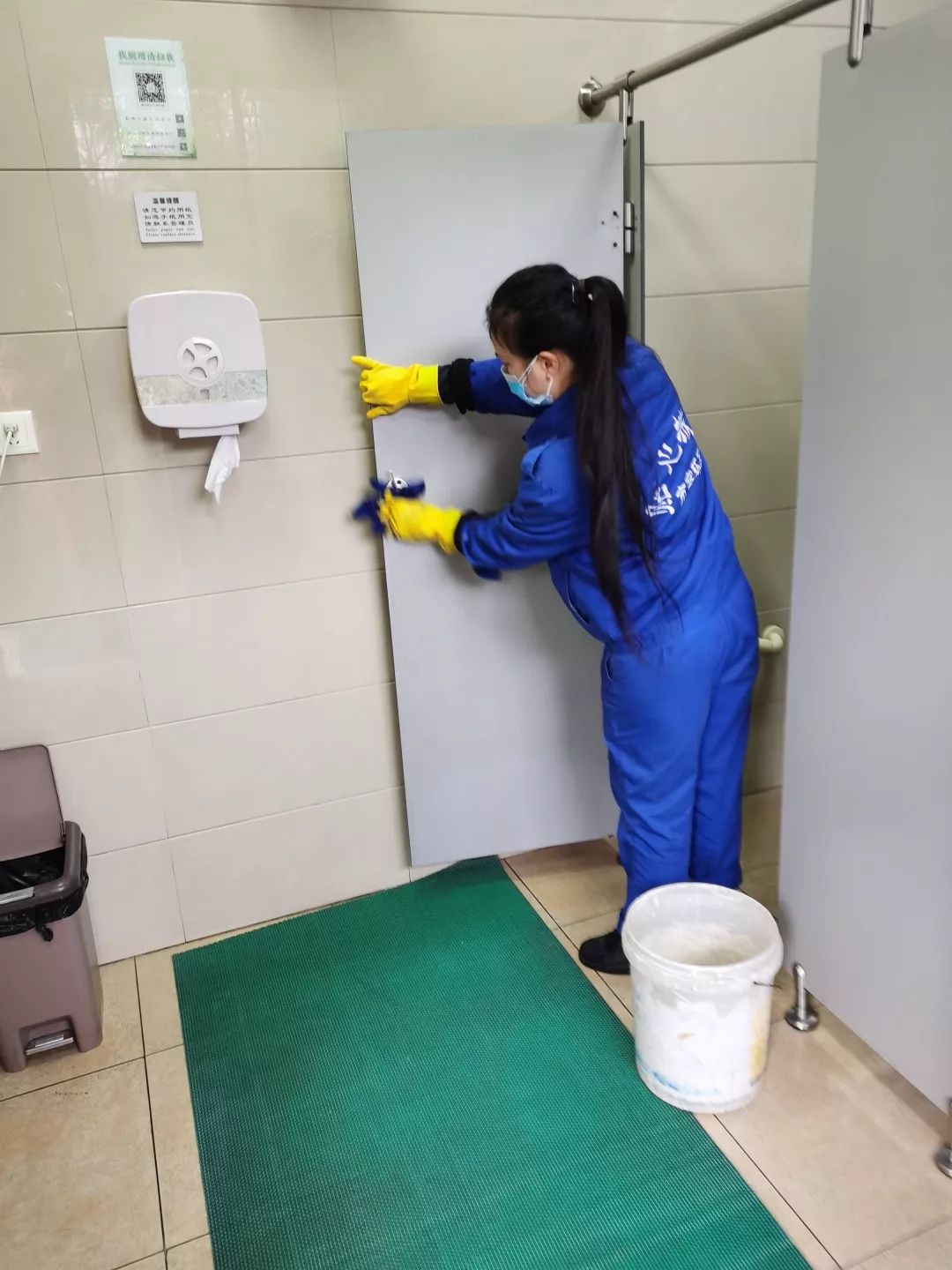 身着蓝色工作服的公厕保洁员频繁擦拭门把手,洗手台,纸巾盒等多处市民